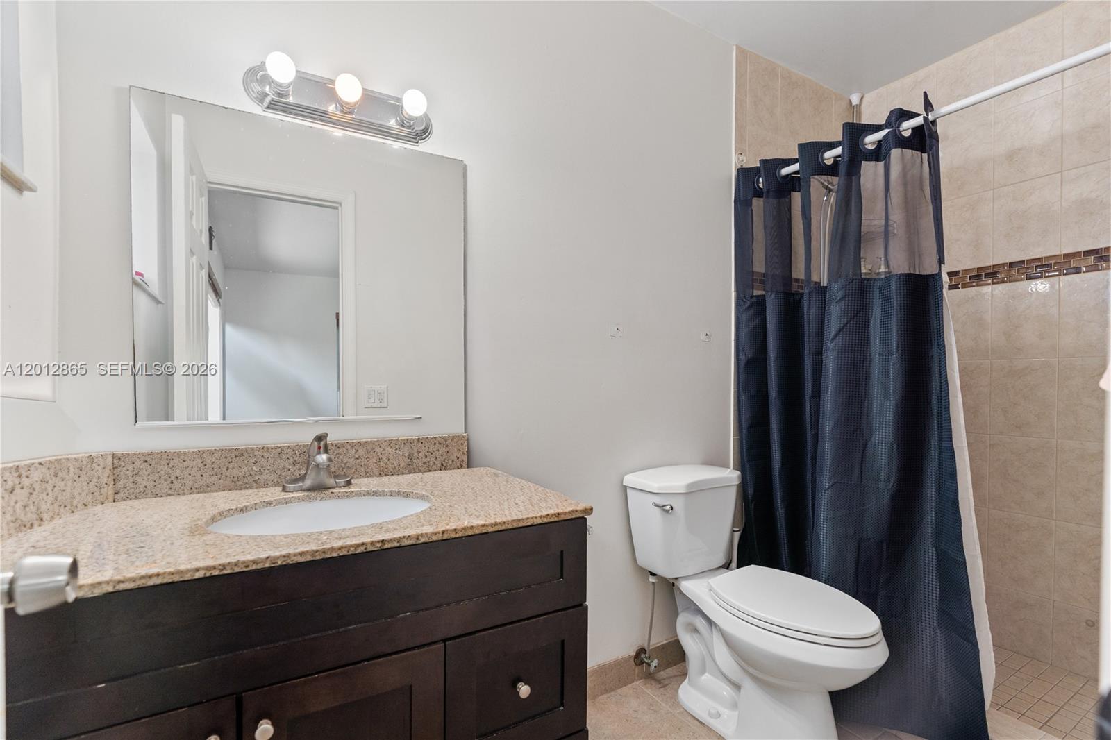 5300 Northwest 30th Place Miami, FL 33142 - Photo 16 of 35 a bathroom with a sink vanity mirror and toilet