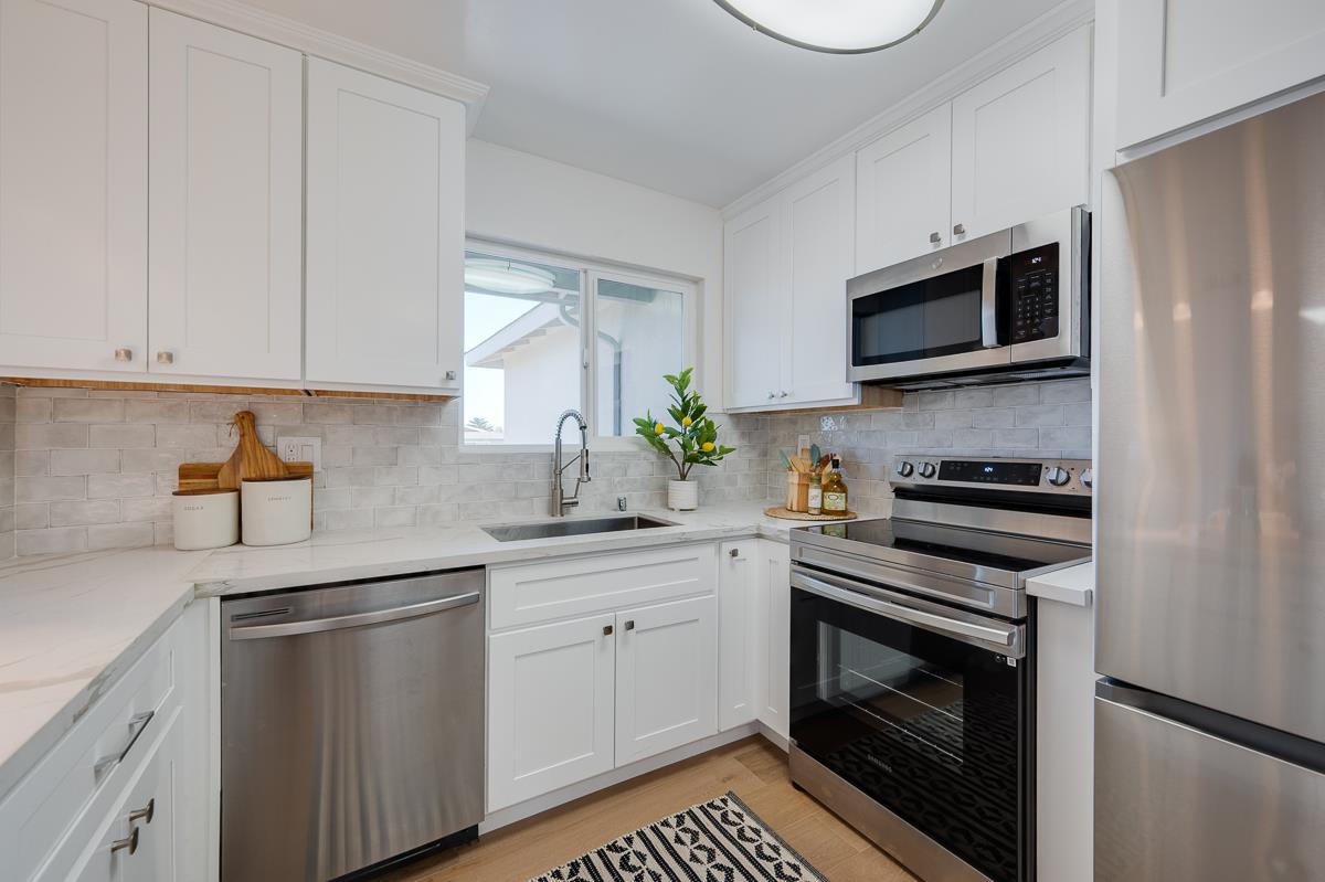 490 Jean Circle Marina, CA 93933 - Photo 17 of 60 a kitchen with stainless steel appliances a stove microwave and sink