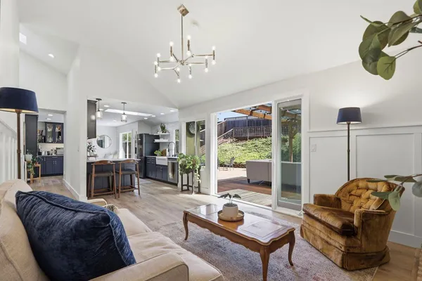 a living room with furniture a chandelier and a rug