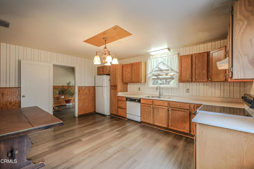 826 Cedar Street Fort Bragg, CA 95437 - Photo 12 of 42 a kitchen with stainless steel appliances granite countertop a refrigerator a sink dishwasher a stove and a dining table with wooden floor