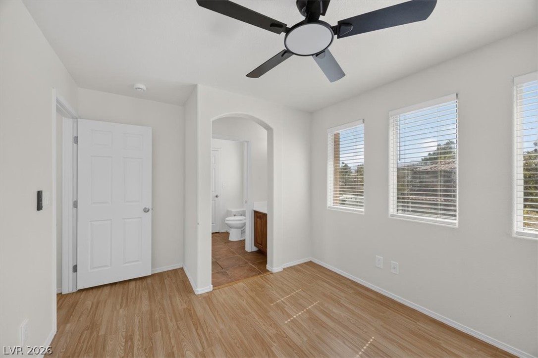 552 Albacate Street Henderson, NV 89015 - Photo 32 of 40 A well-lit bedroom with durable wood-look flooring and an attached private bathroom.