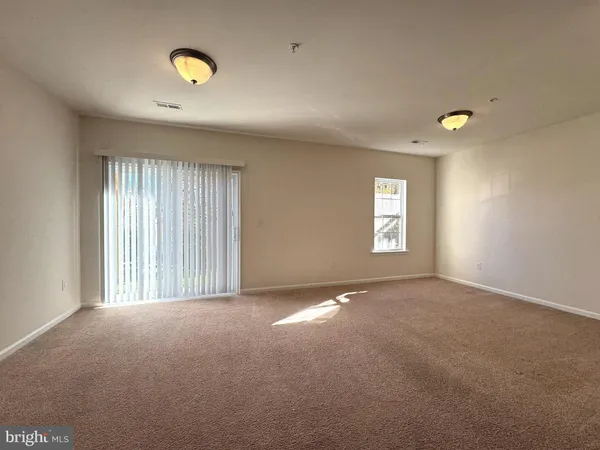 an empty room with windows and mirror