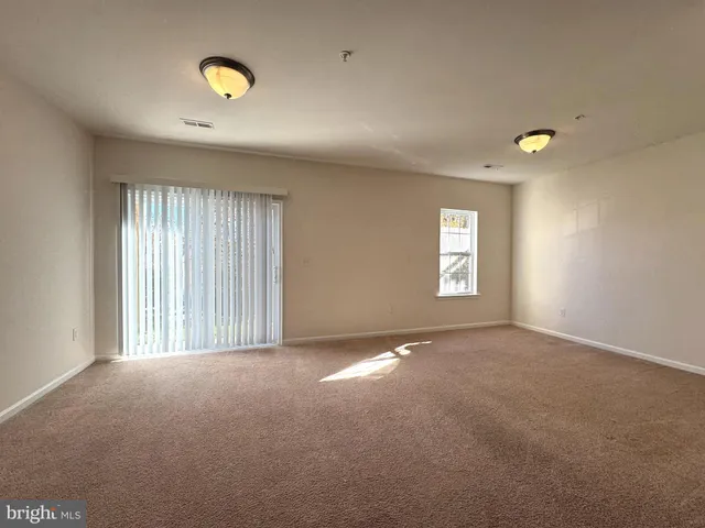 an empty room with windows and mirror