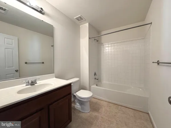 a bathroom with a double vanity sink toilet mirror and shower