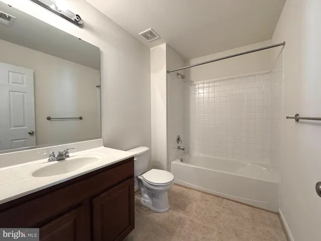 a bathroom with a double vanity sink toilet mirror and shower