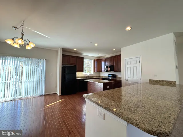 a kitchen with kitchen island granite countertop a sink window and refrigerator