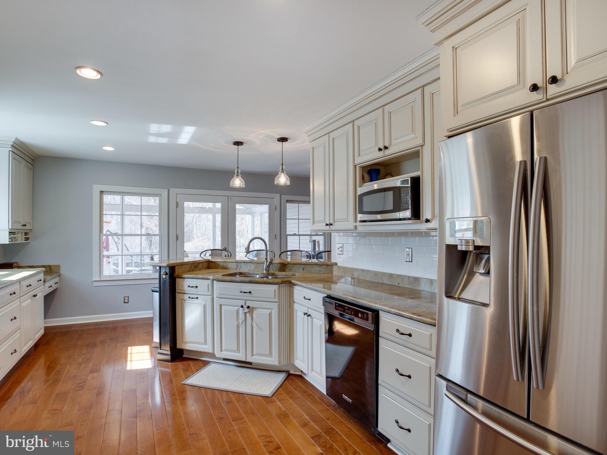 3235 Breckenridge Way Riva, MD 21140 - Photo 11 of 63 a kitchen with stainless steel appliances granite countertop a refrigerator a stove a sink dishwasher and microwave with wooden floor