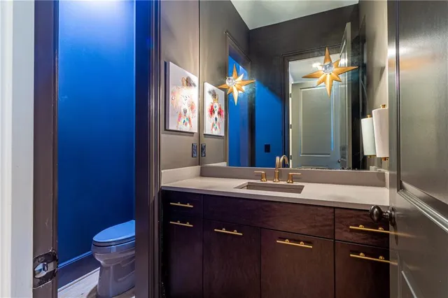 a bathroom with a granite countertop sink toilet and mirror