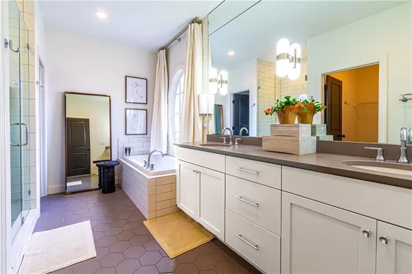 a spacious en suite bathroom with double sink and a mirror