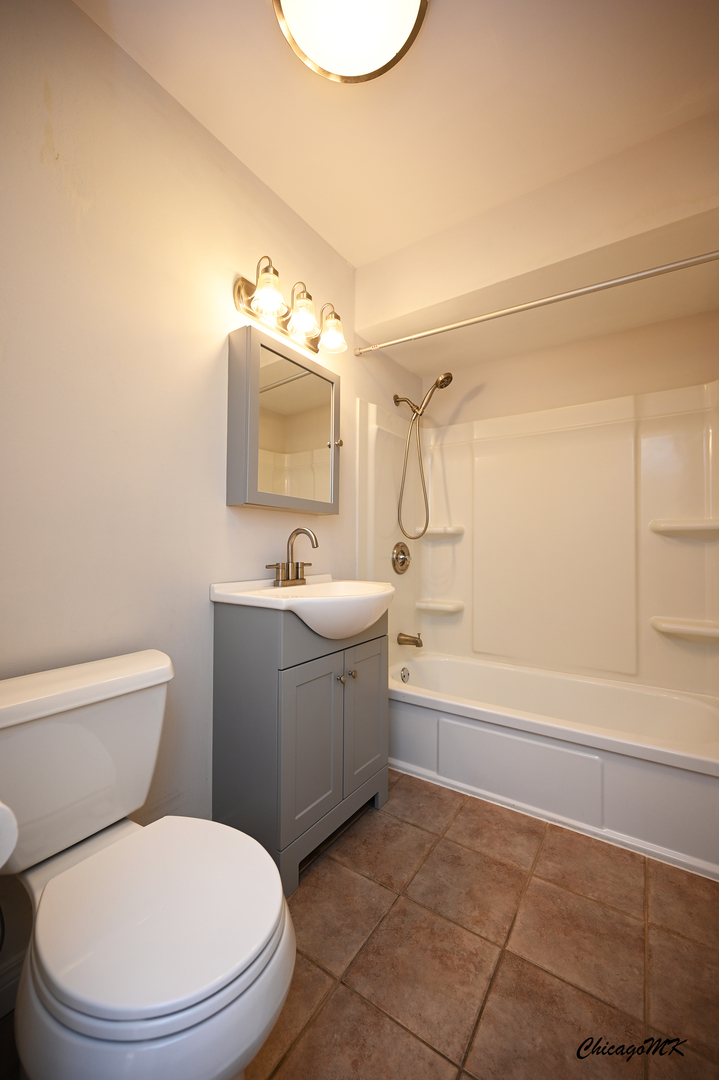 2230 South Goebbert Road, Unit 339 Arlington Heights, IL 60005 - Photo 24 of 38 a bathroom with a toilet a sink a mirror and bathtub