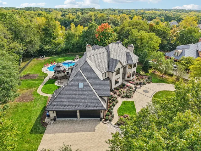 an aerial view of a house with swimming pool and garden