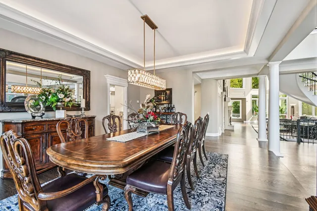 a dining room with furniture a chandelier and wooden floor