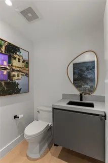 a bathroom with a toilet a sink and a mirror