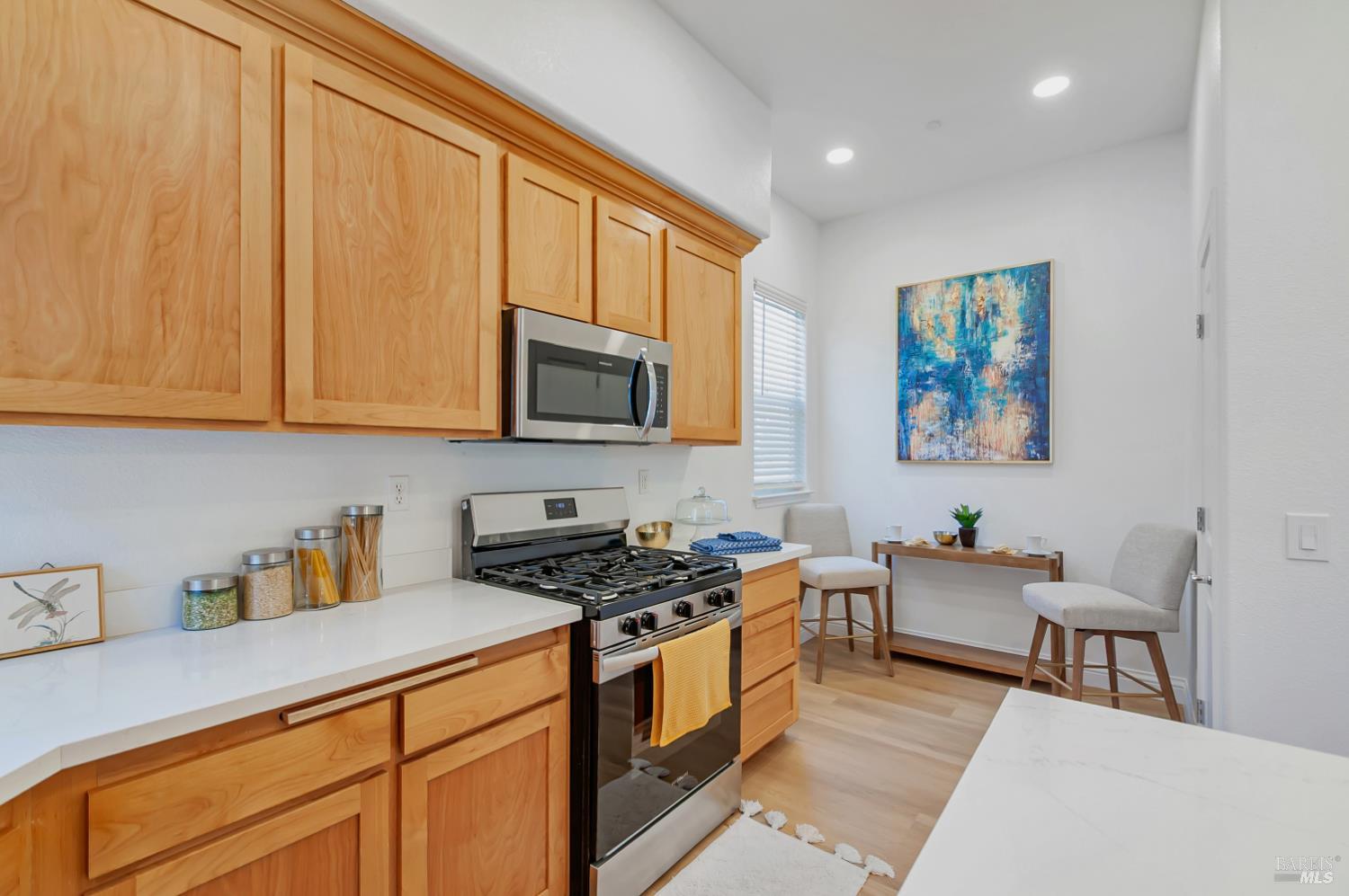 4242 Streamside Drive Santa Rosa, CA 95409 - Photo 11 of 29 a kitchen with stainless steel appliances granite countertop a stove a sink a microwave a dining table and chairs with wooden floor