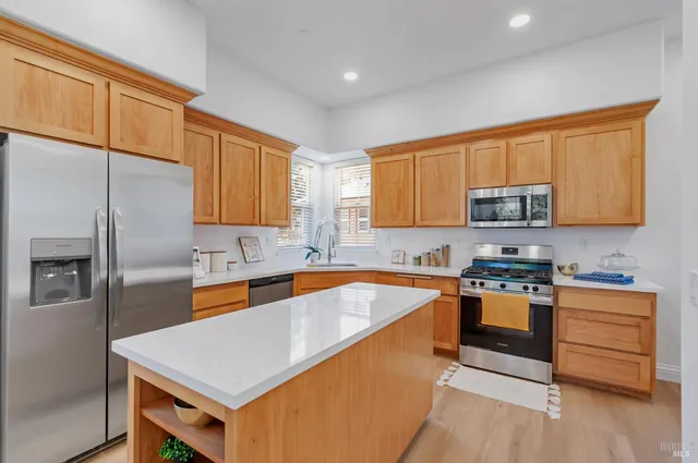 a kitchen with stainless steel appliances granite countertop a sink stove microwave and refrigerator