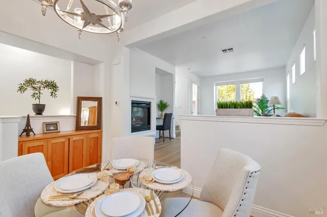 a dining room with furniture a large window and wooden floor