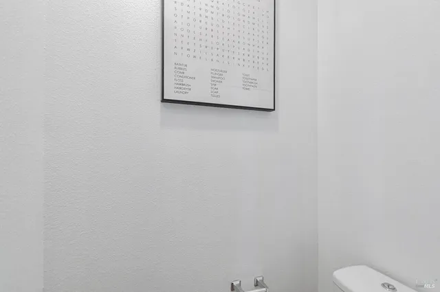 a bathroom with a toilet and a picture