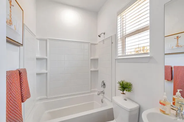 a bathroom with a bathtub shower sink and toilet