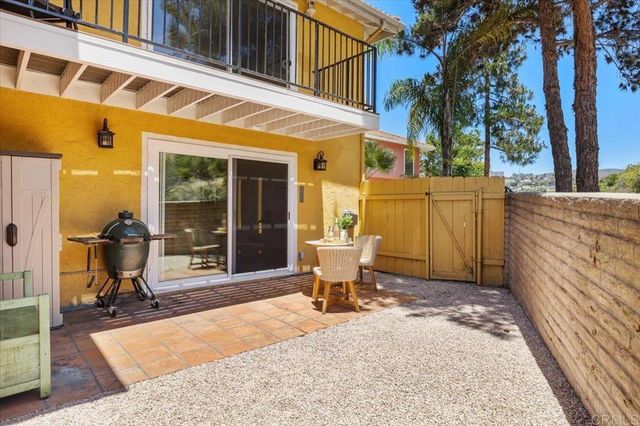 a patio with table and chairs and potted plants