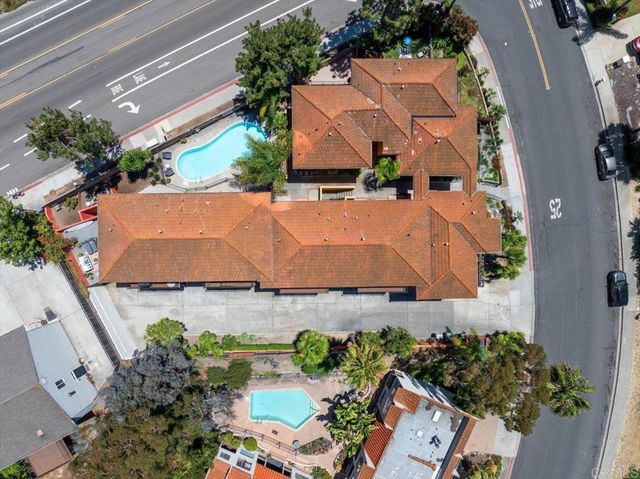 an aerial view of a house with a yard and trees all around