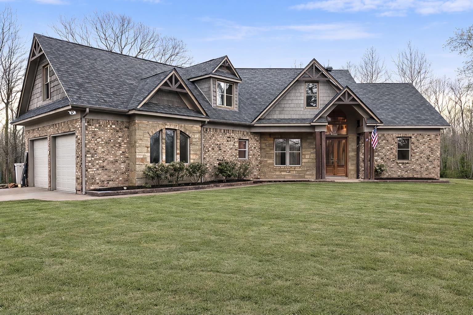 Craftsman-style home featuring a front yard, brick siding, concrete driveway, and an attached garage