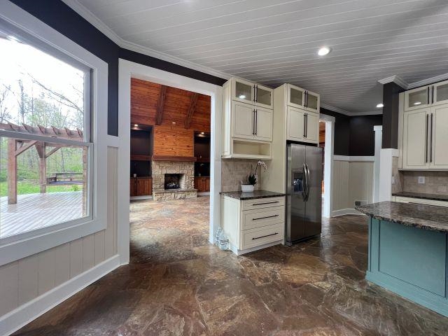 9490 Highway 196 Collierville, TN 38017 - Photo 14 of 39 Kitchen with a wainscoted wall, glass fronted cabinets, ornamental molding, dual tone cabinets, and stainless steel fridge with ice dispenser