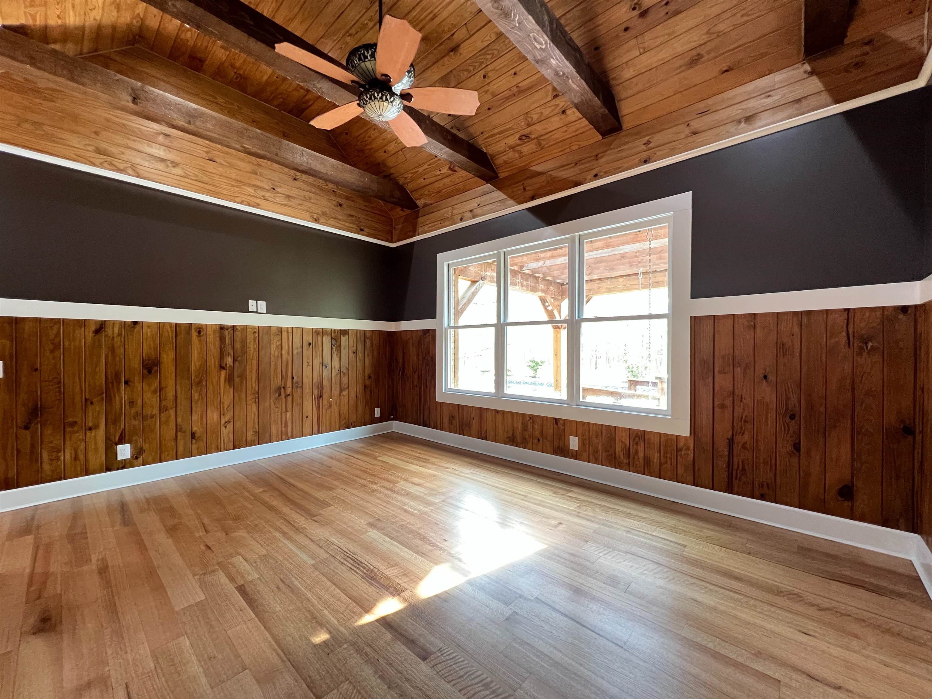 9490 Highway 196 Collierville, TN 38017 - Photo 15 of 39 Primary bedroom featuring wainscoting, wood walls, vaulted ceiling with beams, a ceiling fan, and wooden ceiling