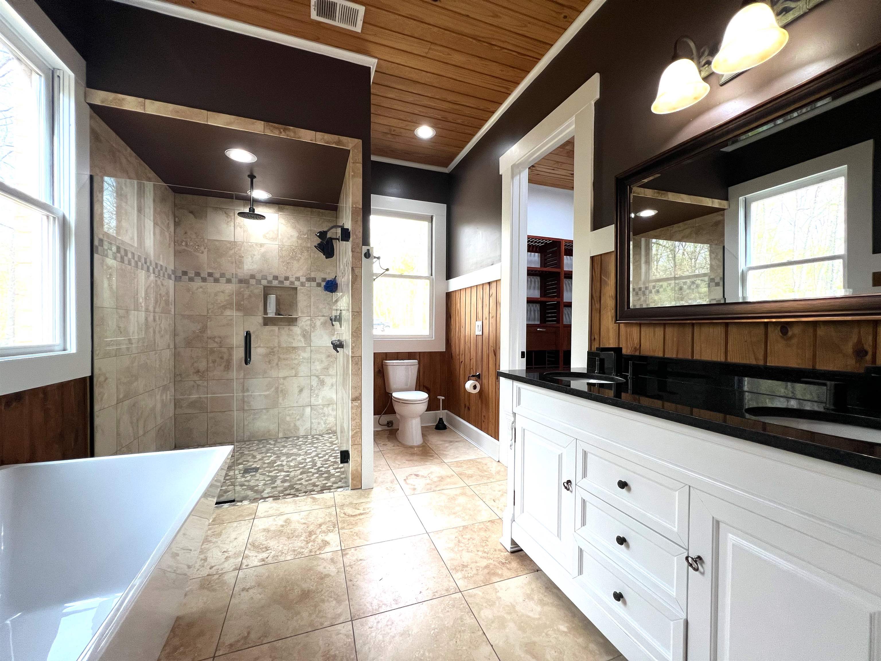 9490 Highway 196 Collierville, TN 38017 - Photo 18 of 39 Full bath featuring a stall shower, a freestanding bath, a wainscoted wall, double vanity, and wooden walls