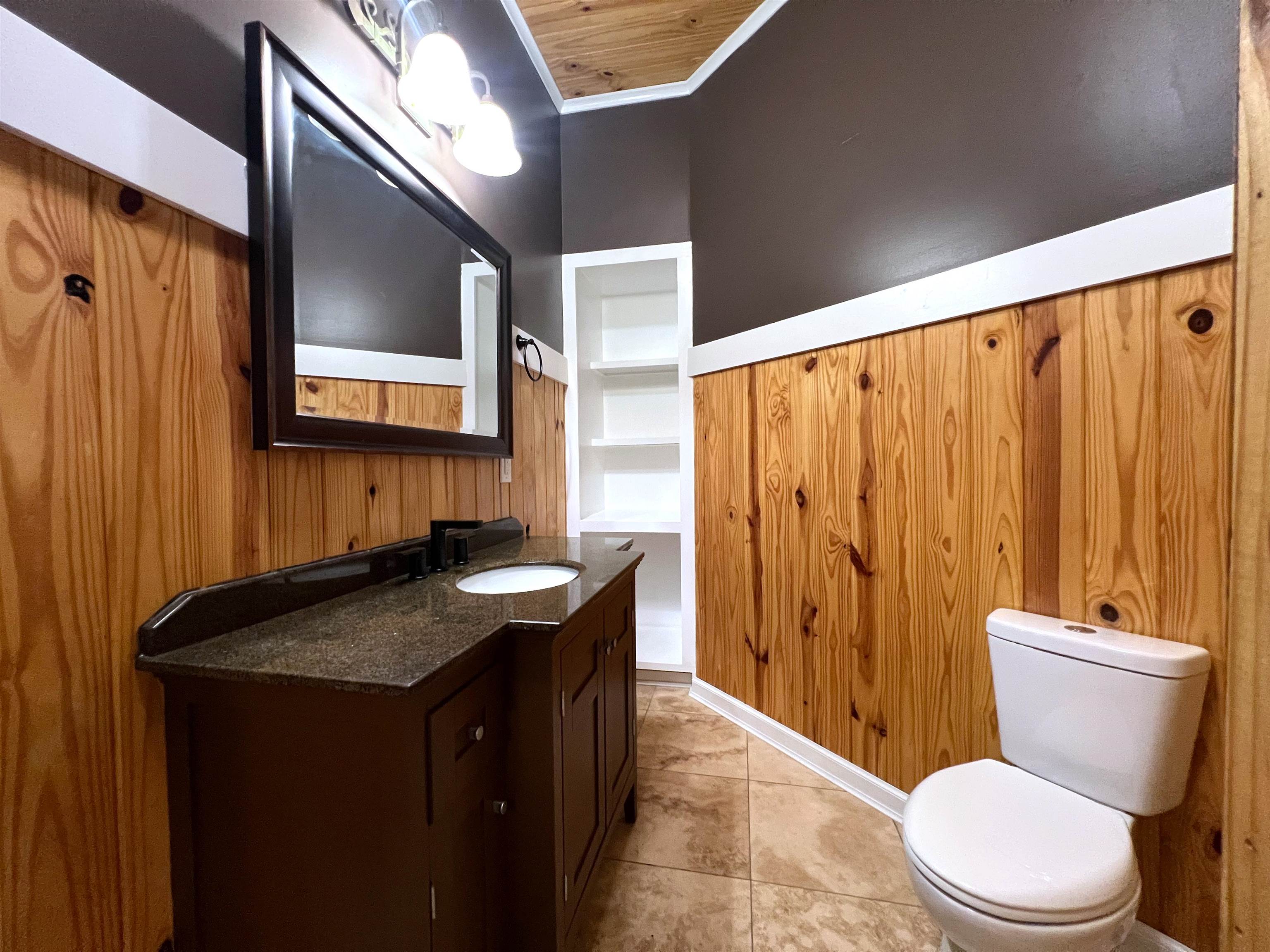 9490 Highway 196 Collierville, TN 38017 - Photo 26 of 39 Half bath featuring wood walls, vanity, ornamental molding, and light tile patterned floors