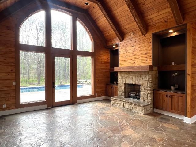 9490 Highway 196 Collierville, TN 38017 - Photo 4 of 39 Den featuring stone floors, wooden walls, a fireplace, and a high wooden beamed ceiling