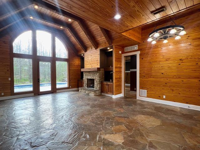 9490 Highway 196 Collierville, TN 38017 - Photo 5 of 39 Den featuring wood walls, stone flooring, a stone fireplace, and a high wood beamed ceiling