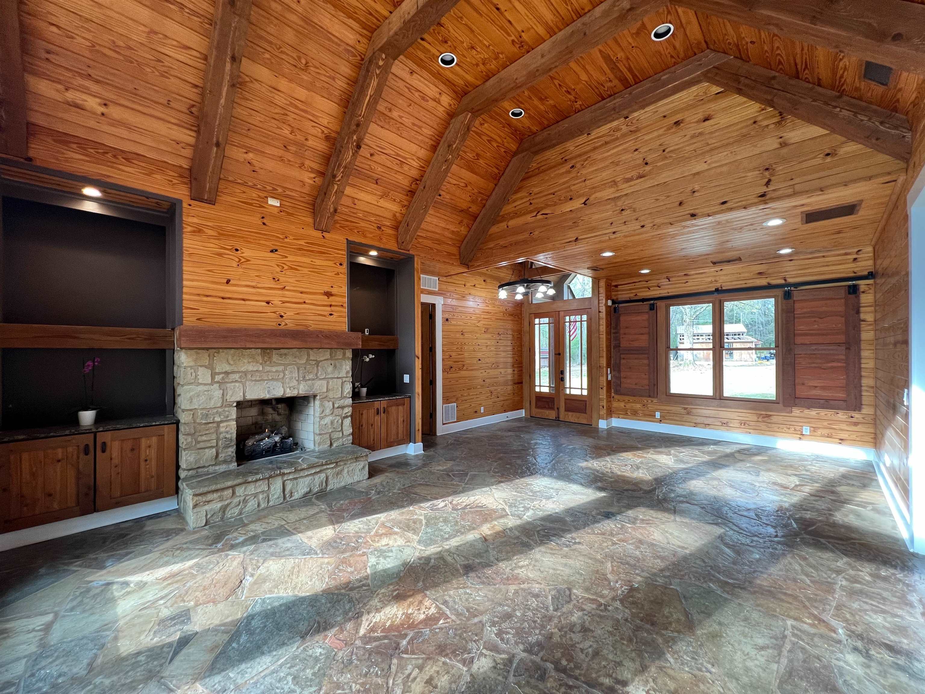 9490 Highway 196 Collierville, TN 38017 - Photo 7 of 39 Den featuring French doors, wooden walls, stone floors, recessed lighting, and a fireplace