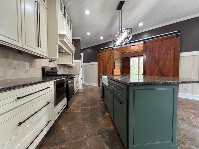 9490 Highway 196 Collierville, TN 38017 - Photo 9 of 39 Kitchen with two tone cabinetry, a wainscoted wall, a barn door, dark stone counters, and stone floors