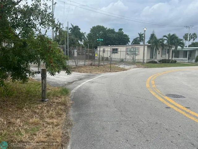 a view of dirt field with trees in background