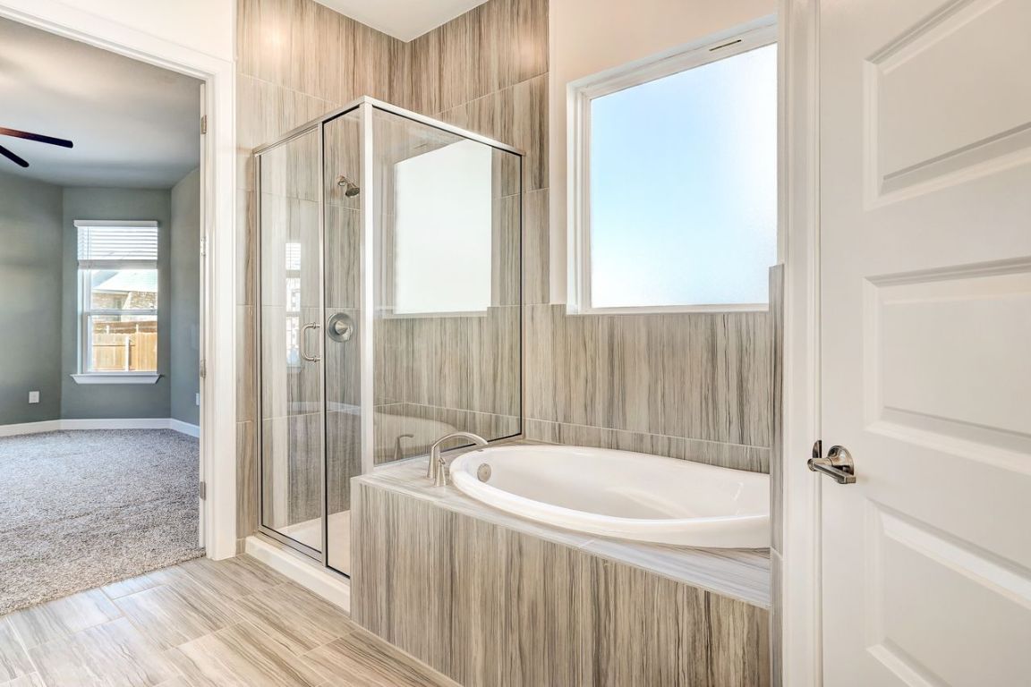 4705 Sea Salt Drive Austin, TX 78747 - Photo 11 of 19 Full bathroom featuring a garden tub and a stall shower