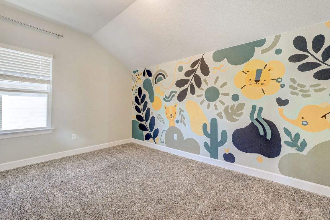 4705 Sea Salt Drive Austin, TX 78747 - Photo 13 of 19 Carpeted spare room featuring vaulted ceiling and baseboards