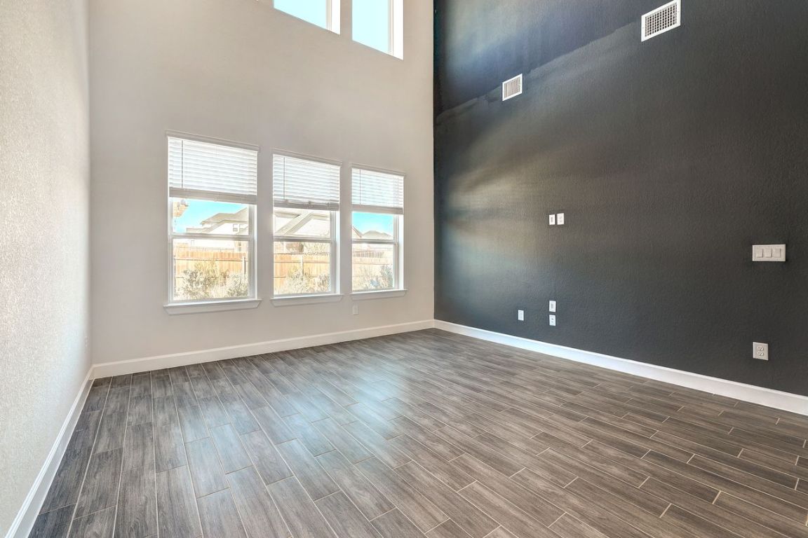 4705 Sea Salt Drive Austin, TX 78747 - Photo 8 of 19 Unfurnished room featuring wood finish floors and a towering ceiling