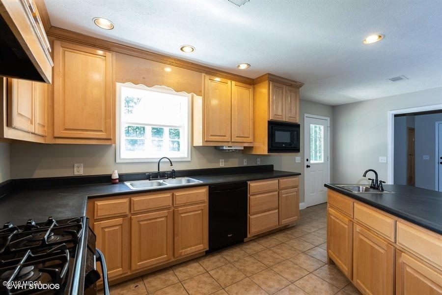 4071 Hollis Road Roberta, GA 31078 - Photo 11 of 22 a kitchen with granite countertop a stove a sink and a microwave
