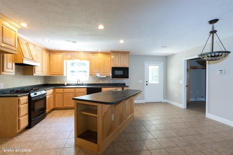 4071 Hollis Road Roberta, GA 31078 - Photo 6 of 22 a kitchen with stainless steel appliances granite countertop a sink stove and refrigerator