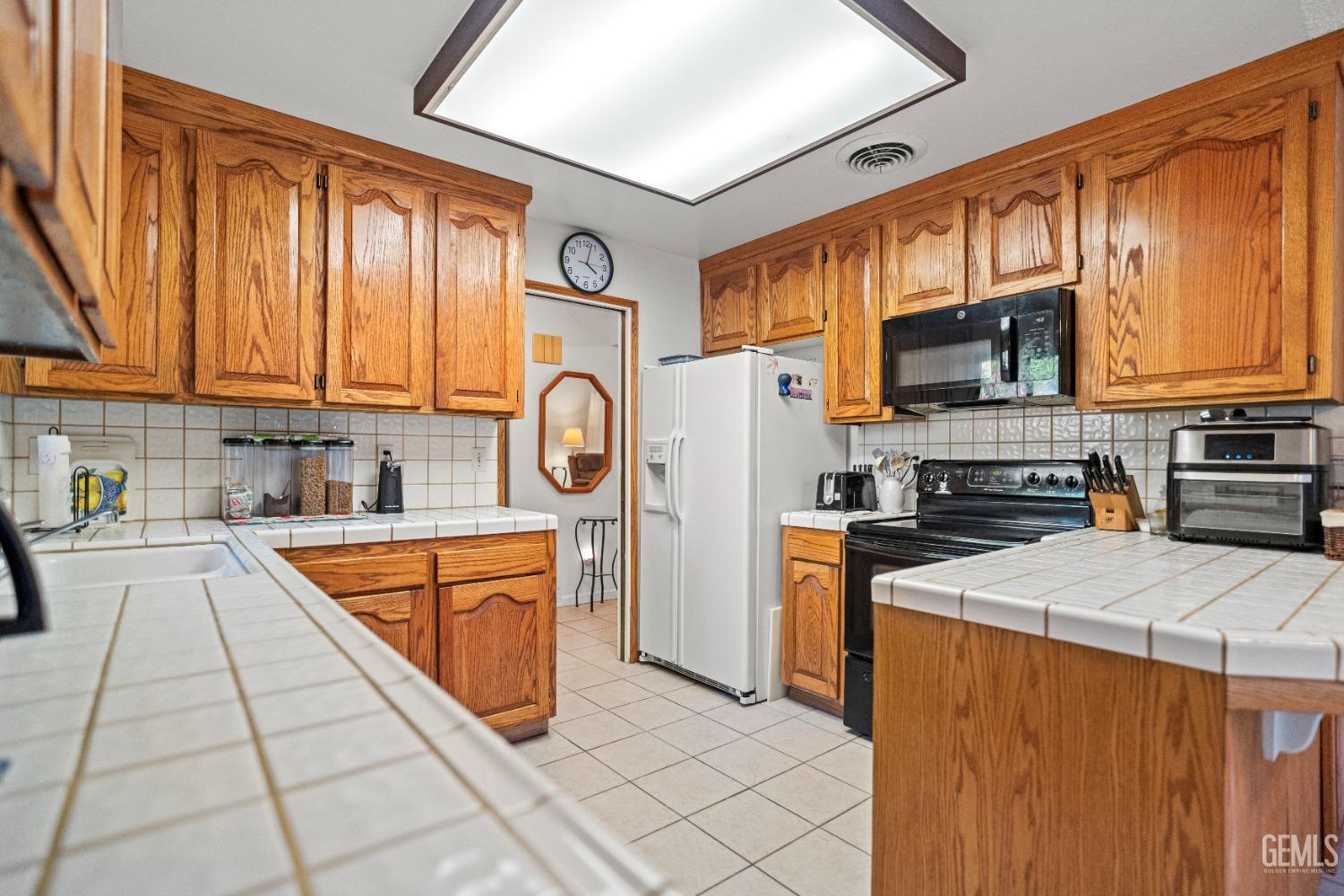 Undisclosed Address Bakersfield, CA 93306 - Photo 21 of 56 a kitchen with stainless steel appliances granite countertop a stove top oven a refrigerator a sink and dishwasher with wooden cabinets