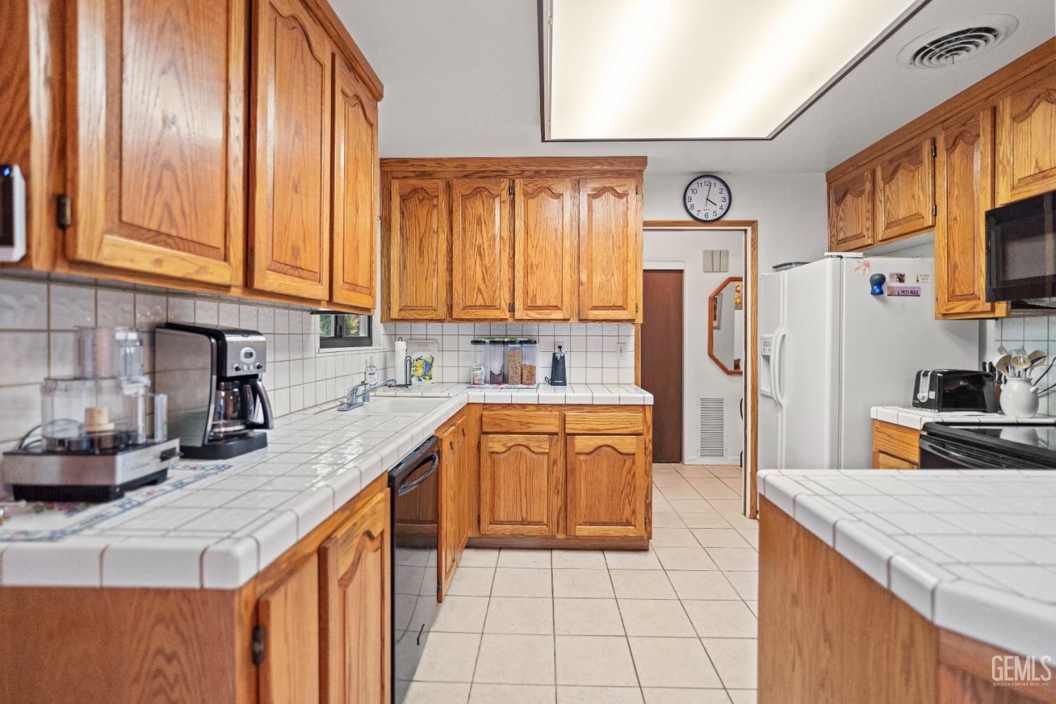 Undisclosed Address Bakersfield, CA 93306 - Photo 22 of 56 a kitchen with stainless steel appliances granite countertop a refrigerator a sink dishwasher a stove with wooden cabinets and a stove