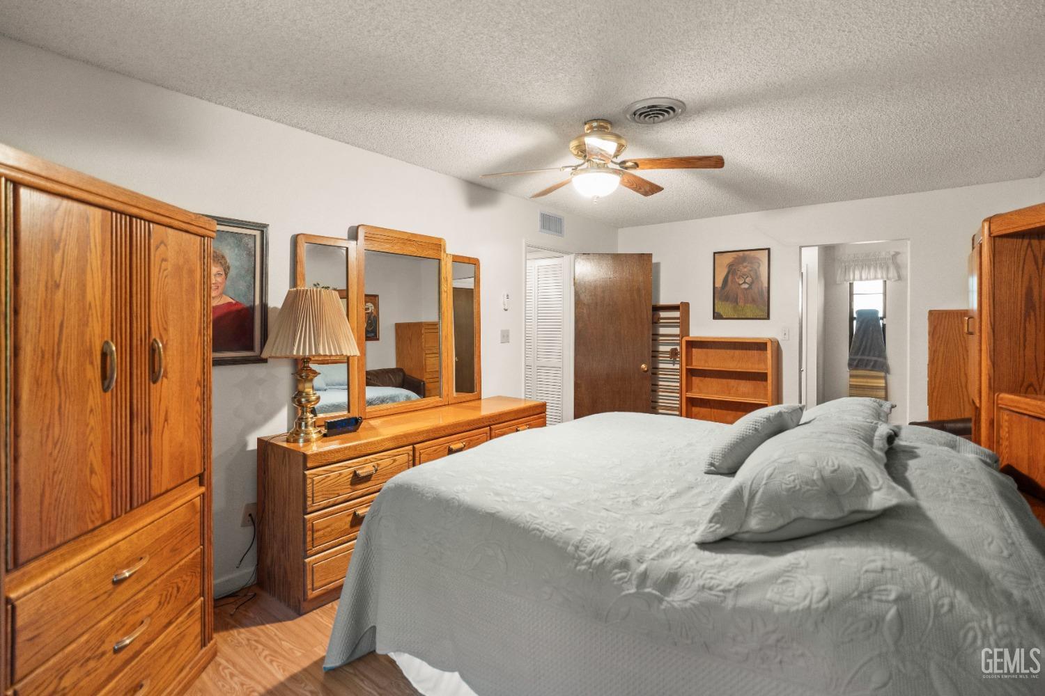 Undisclosed Address Bakersfield, CA 93306 - Photo 31 of 56 a bedroom with a large bed a flat tv screen and dresser