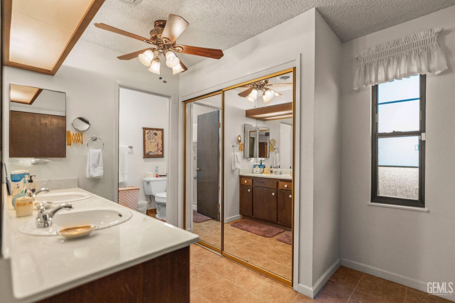 Undisclosed Address Bakersfield, CA 93306 - Photo 32 of 56 a en suite bathroom with a sink a large mirror and a shower
