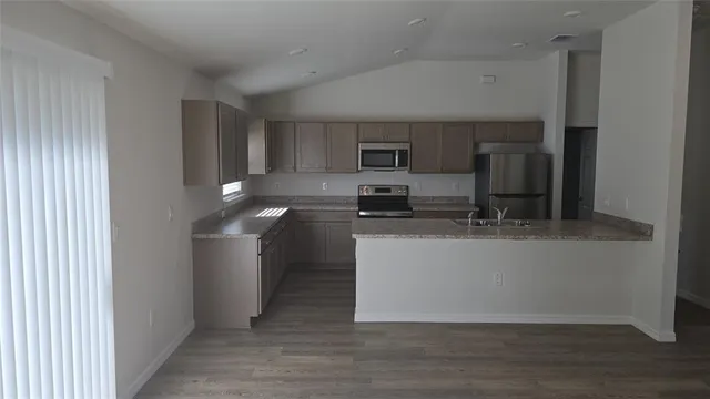 a kitchen with a sink cabinets and wooden floor