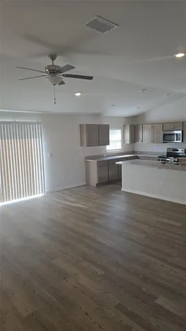 a view of a kitchen with a sink wooden floor and a window