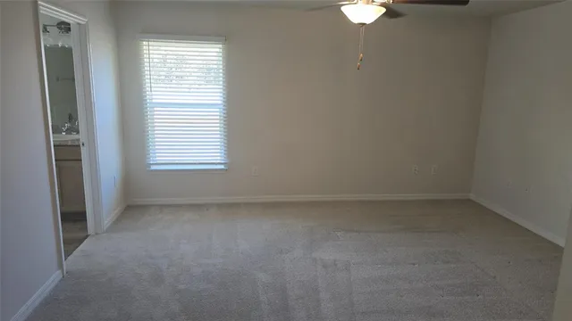 a view of an empty room with a chandelier fan