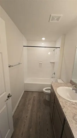 a bathroom with a granite countertop sink a toilet and shower