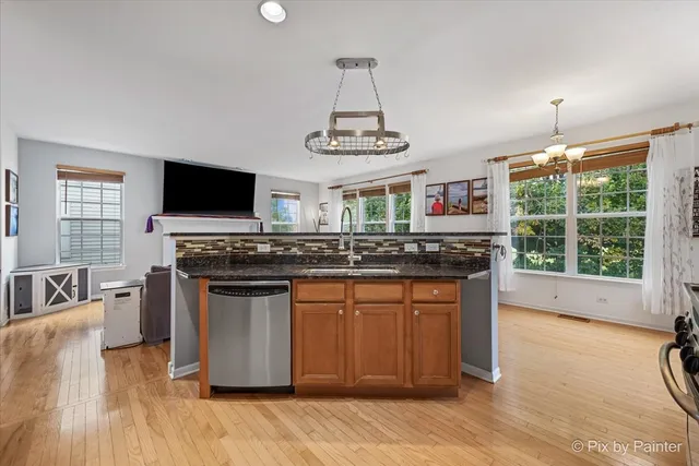 a kitchen with stainless steel appliances granite countertop a stove and a wooden cabinets