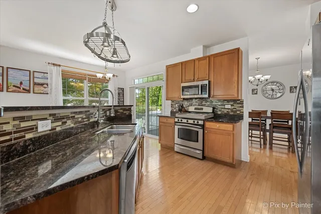 a kitchen with stainless steel appliances granite countertop a stove refrigerator and microwave