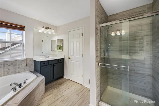 a bathroom with a tub sink shower and mirror